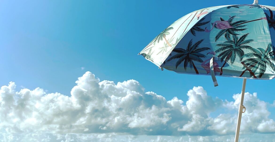 white and green umbrella on beach shore during daytime