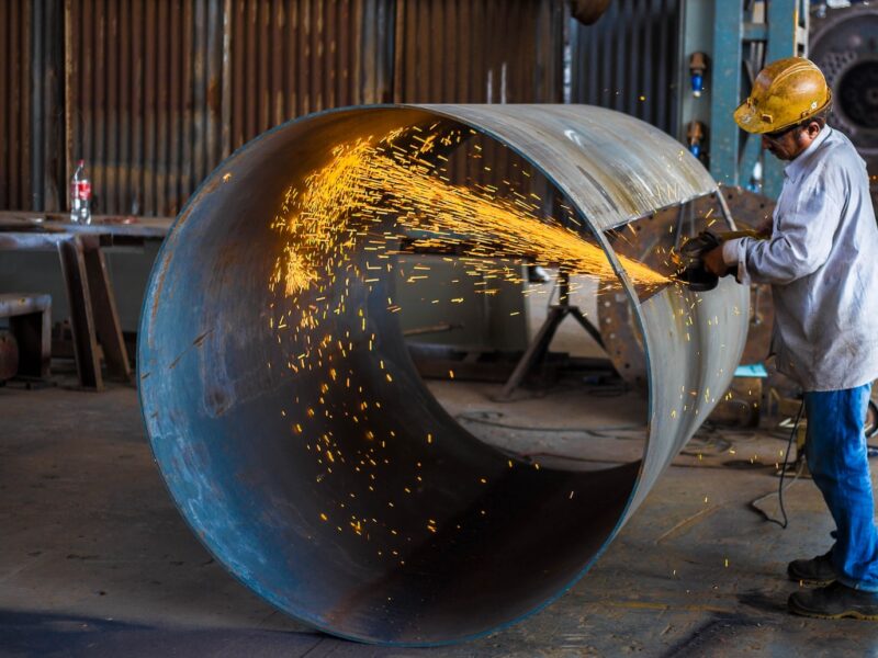man wearing yellow hard hat holding angle grinder