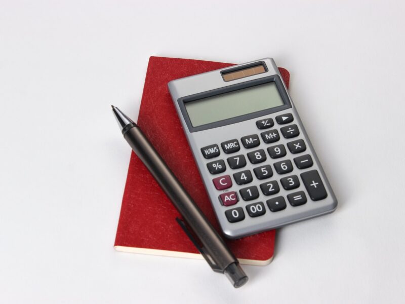 black and silver calculator beside black pen